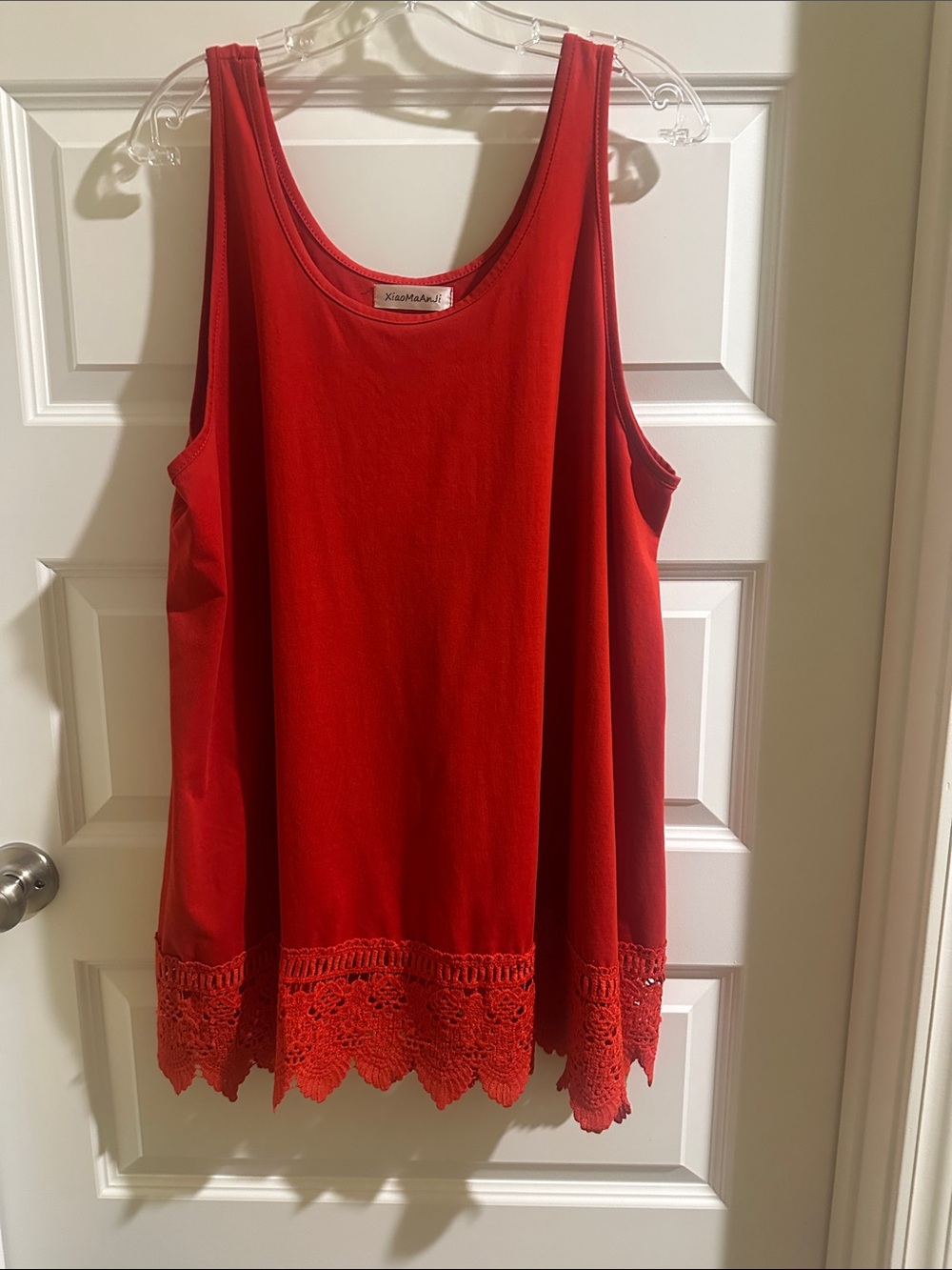 Contemporary women's sleeveless tank top with lace hem detail.